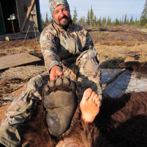 Cory comparing his foot to the back foot of a ten foot brown bear.