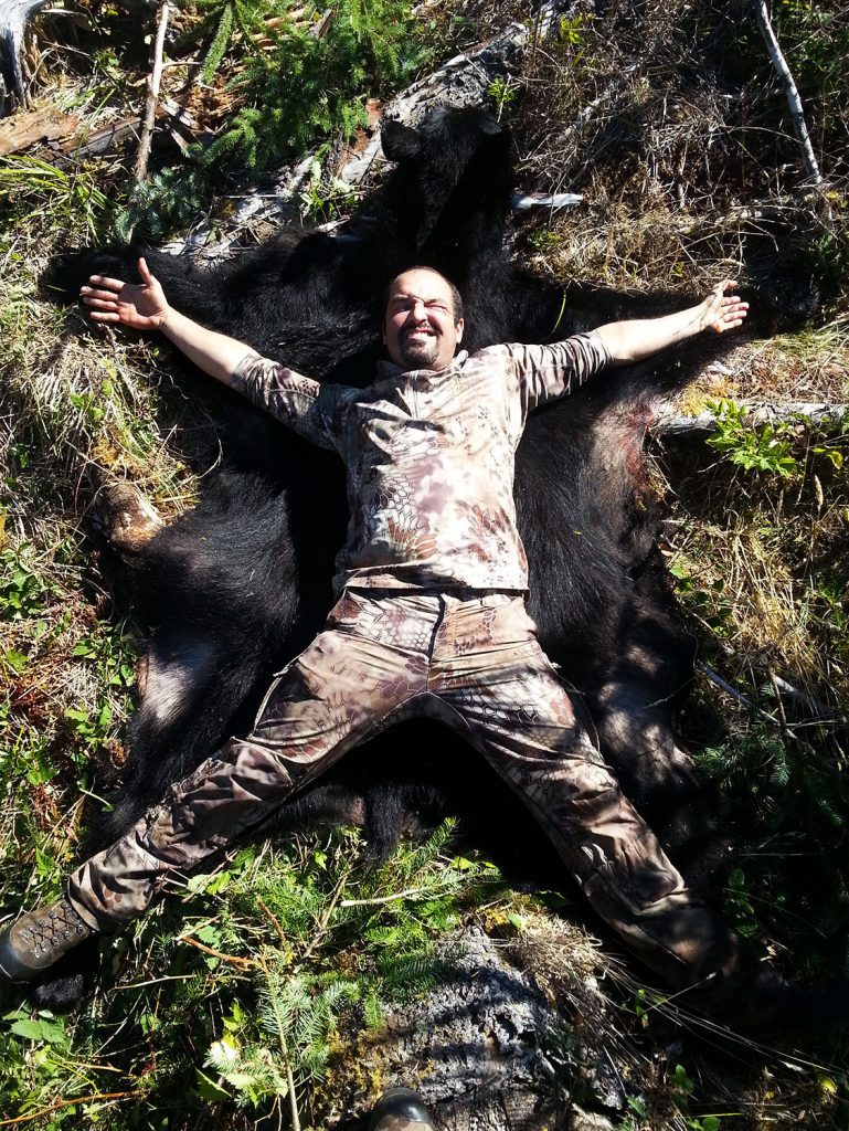 Cory-Glauner Washington black bear OLO1 » Outdoors International Cory laying on Brandon's Washington black bear.