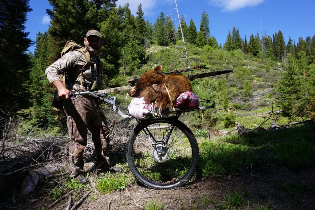 Russ using the Honey Badger Wheel to pack out Mat's bear
