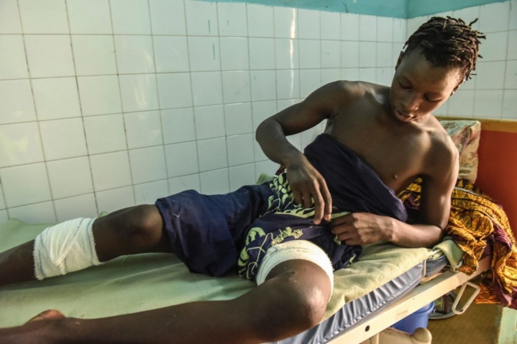 Ali Fall lays on a hospital bed after being attacked by a hippo