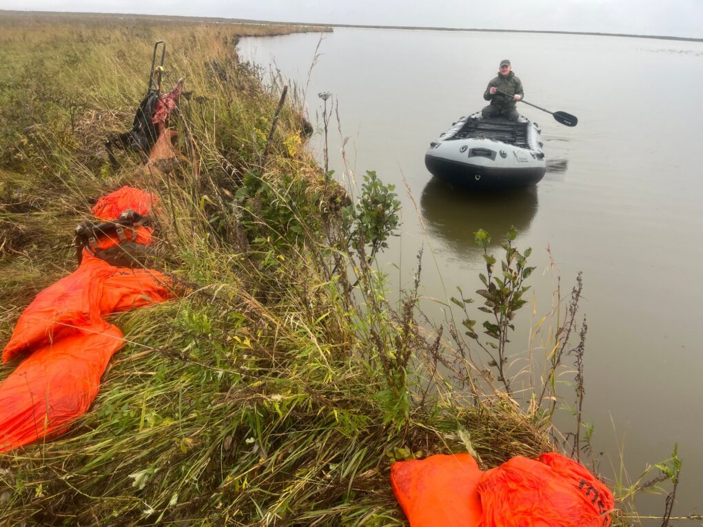 Rex Skiles — hunter paddling inflatable boat on tundra river (Alaska, 2026)